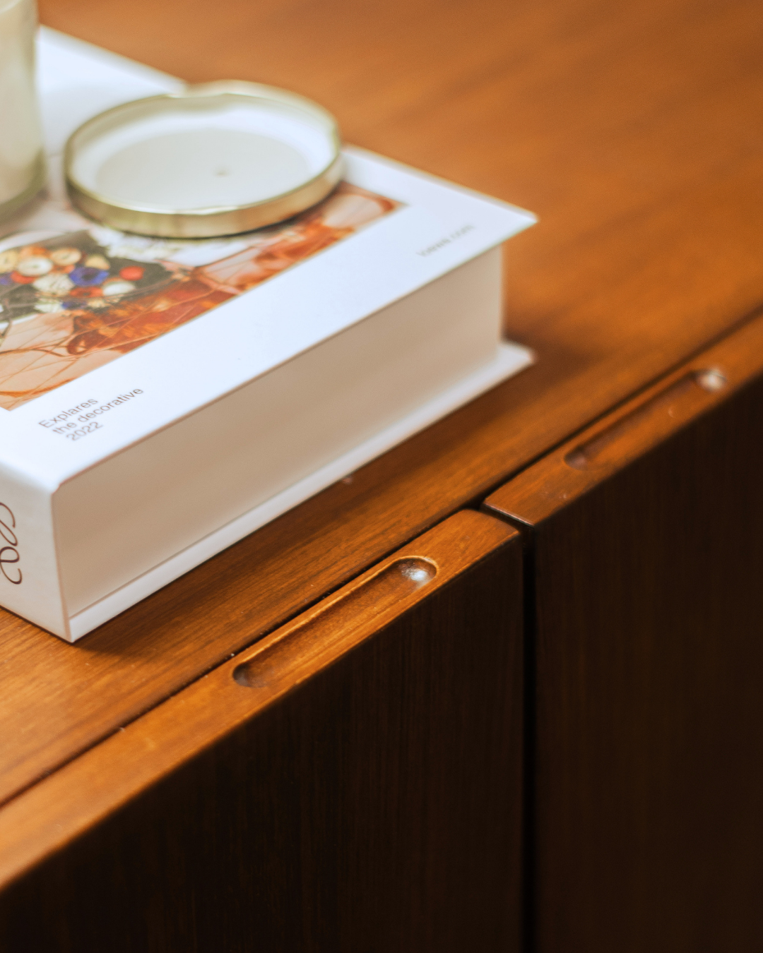 A design book resting on an Arksmith wooden cabinet